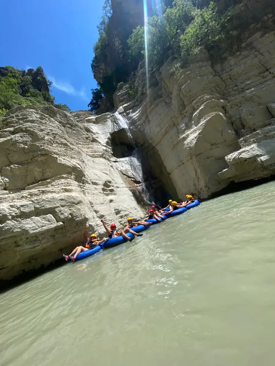 Tubers floating up to a small waterfall in Osum Canyon
